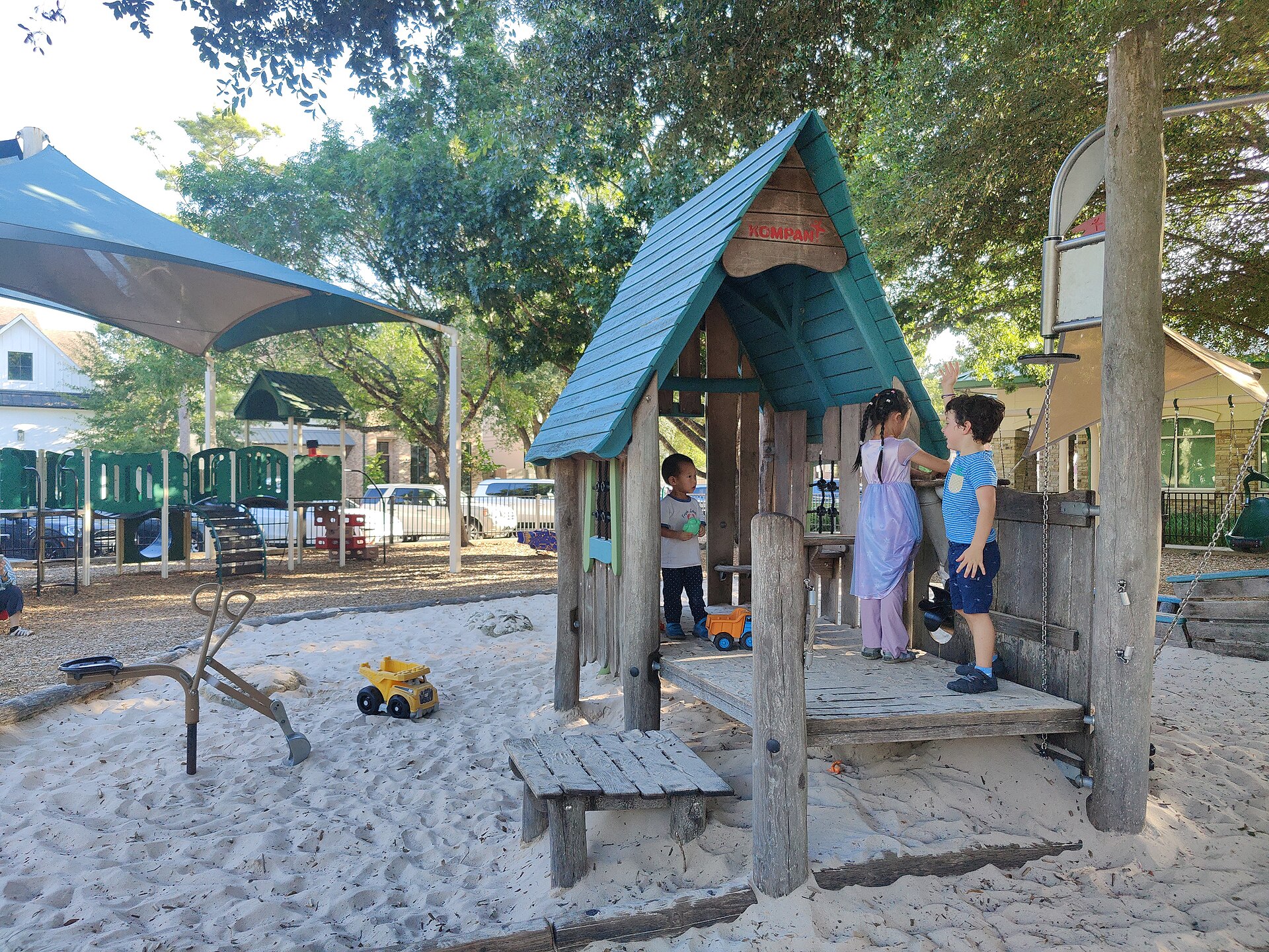 Children on a wooden playground structure in sand